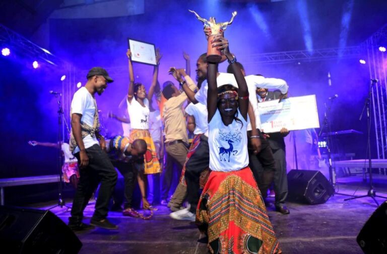 Une chanteuse du groupe brandissant le trophée remis à la finale. Photo: Facebook.