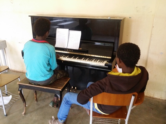 Students during a piano lesson. Photo courtesy of Senai Andemariam