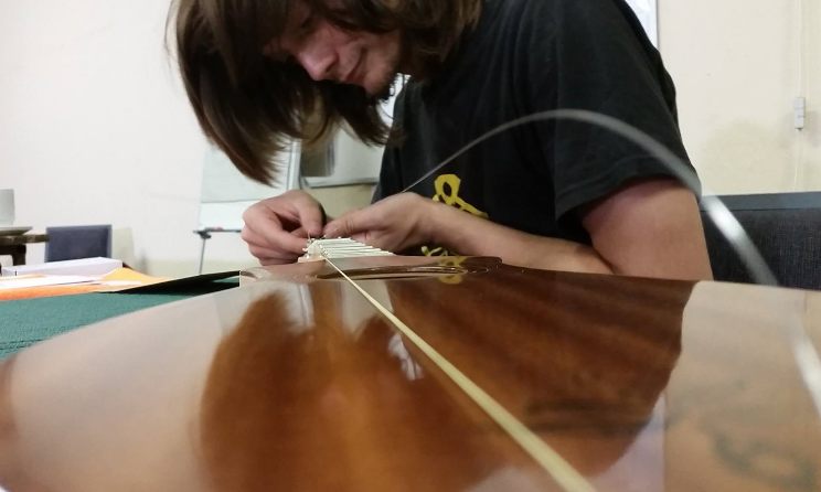 A student stringing his newly built dulcimer.