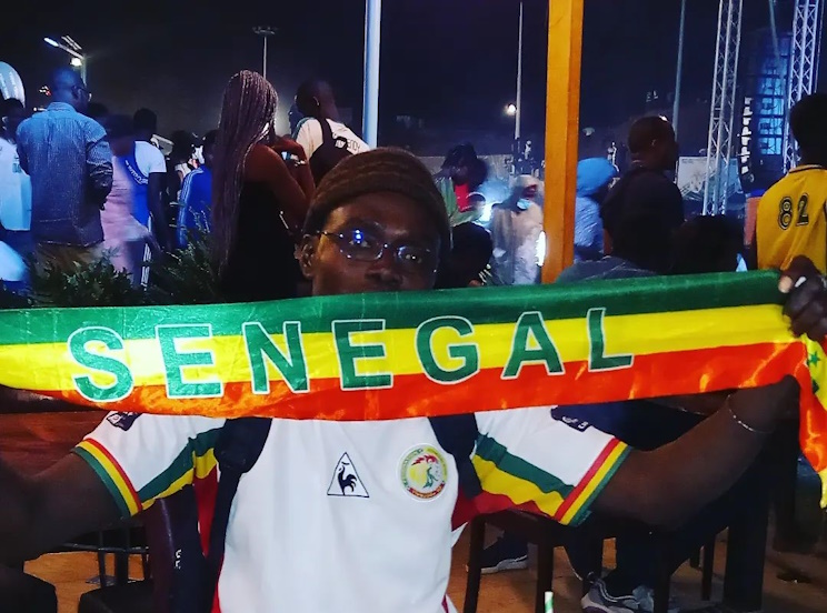 Le rappeur et activiste sénégalais Ode Mbaye arborant fièrement le drapeau du Sénégal lors d'une manifestation en 2022 à Dakar